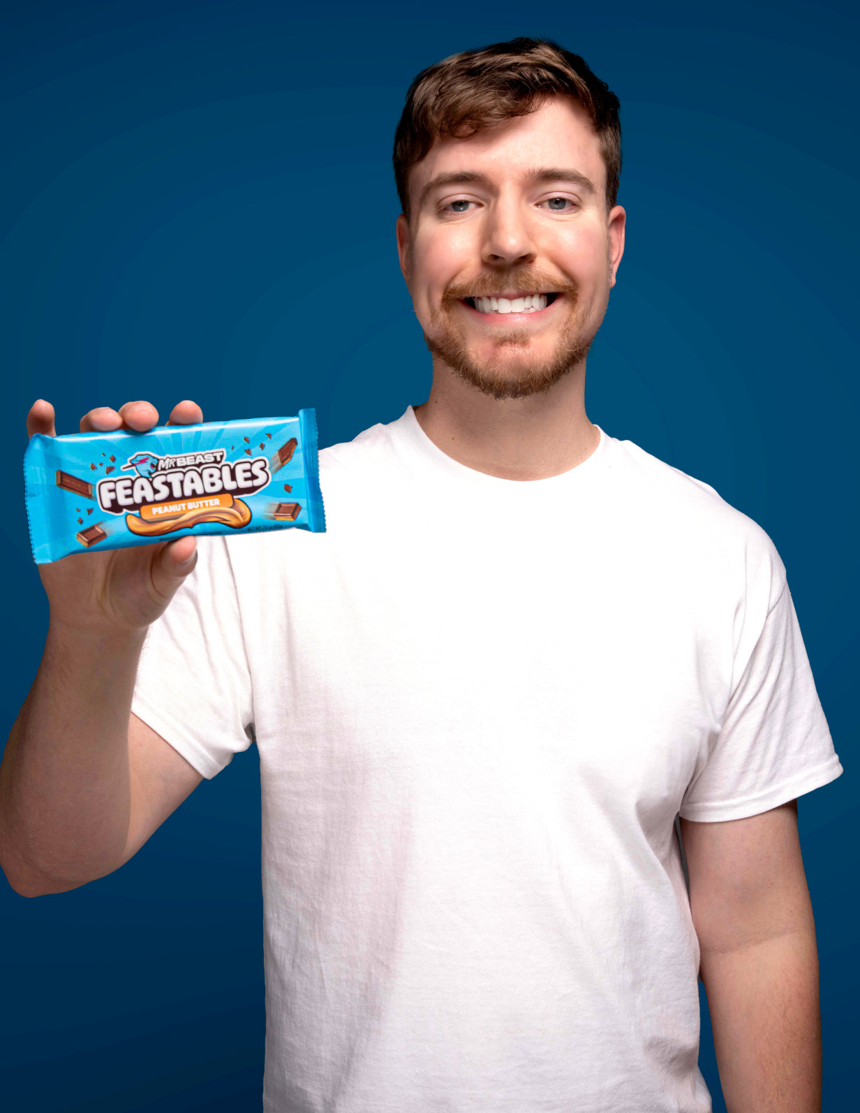 Pictured: MrBeast holding a Feastables peanut butter chocolate bar
