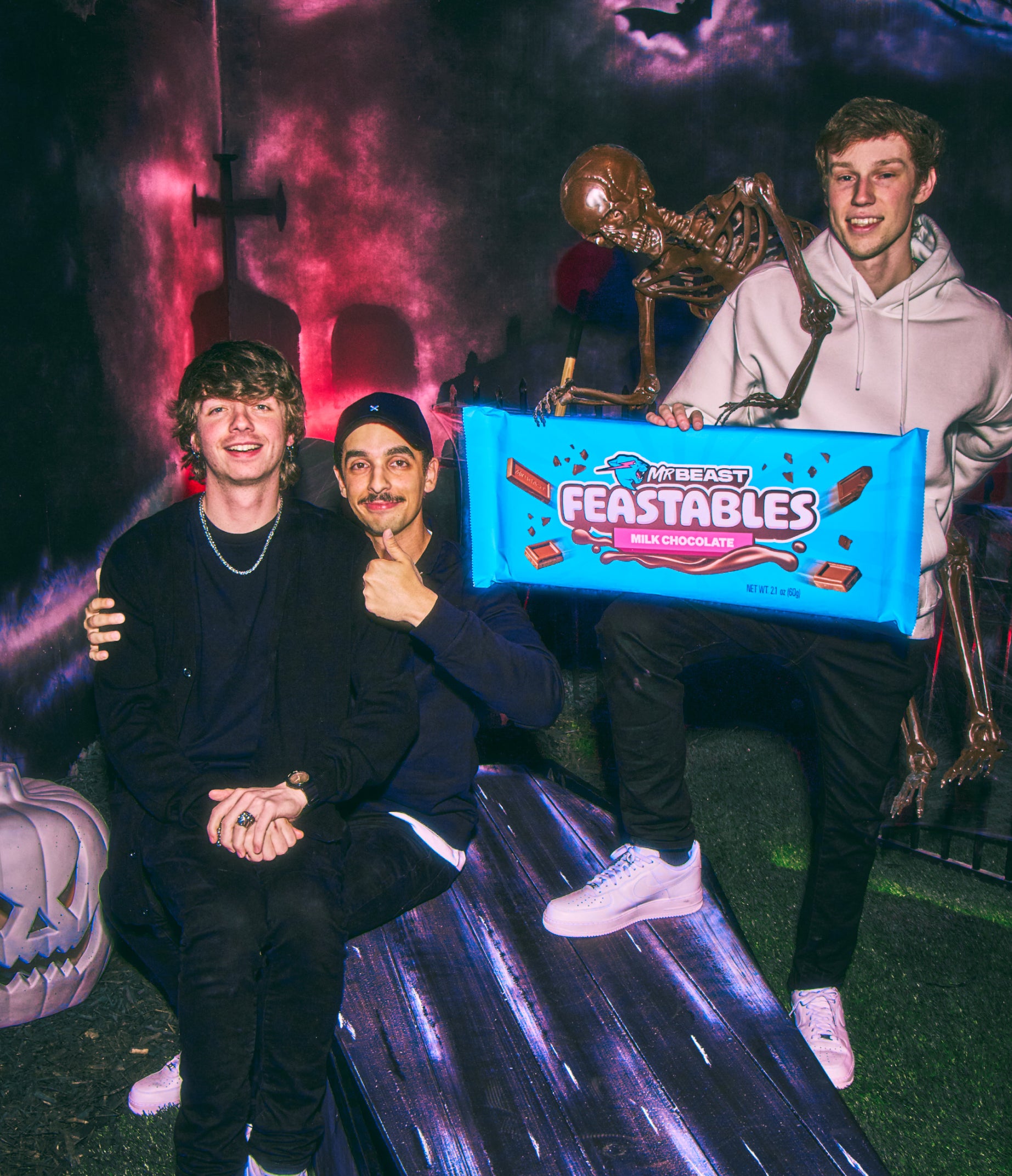 Karl, Tareq and Nolan in a graveyard with a skeleton trying to steal their giant Feastables chocolate bar