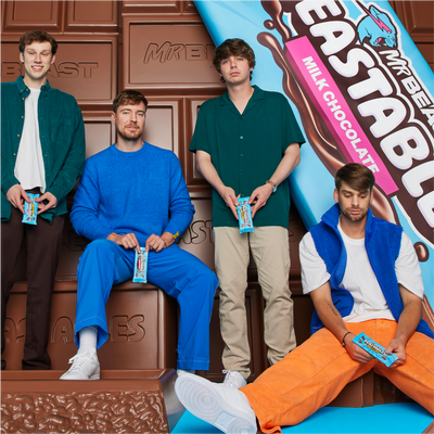 The feastables crew posing near life size chocolate bars 